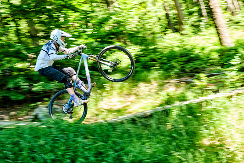 Mountainbiker fährt mit einem Wheelie über einen Flowtrail im Bikepark 1024