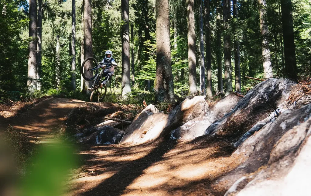 Mountainbiker hebt auf dem relOX das Vorderrad neben einer felsigen Trailpassage an.